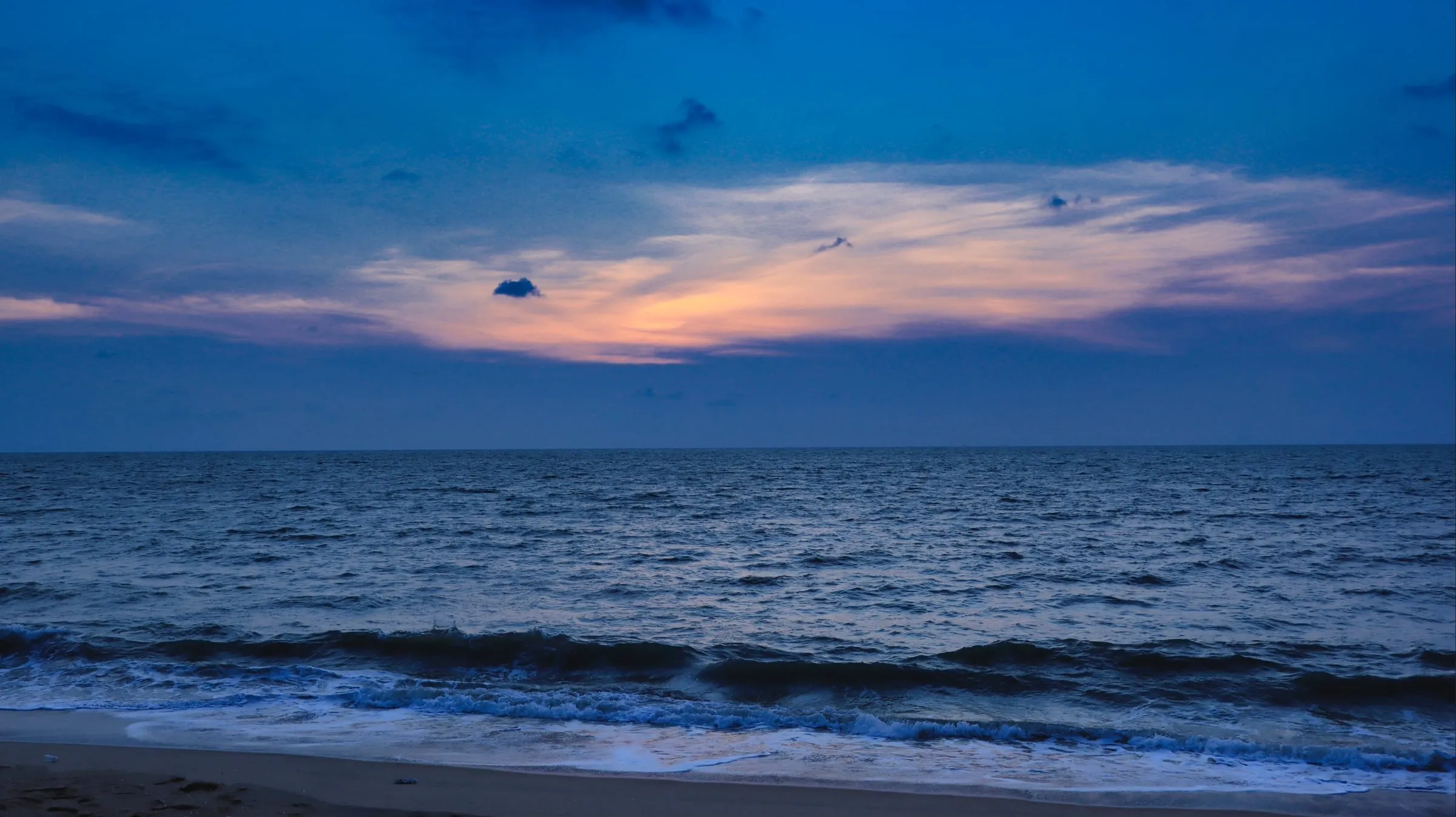 Kannur beach at sunset: the sky turning blue, with a last band of orange light over the sea